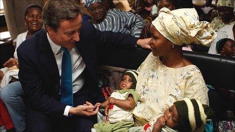 David Cameron chats to a mother of twins at a clinic in Lagos