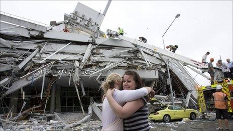 Two women hug each other in front of a collapsed building in central Christchurch February 22, 2011