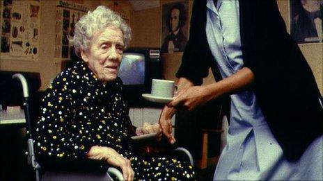 A nurse helping an elderly woman in a wheelchair