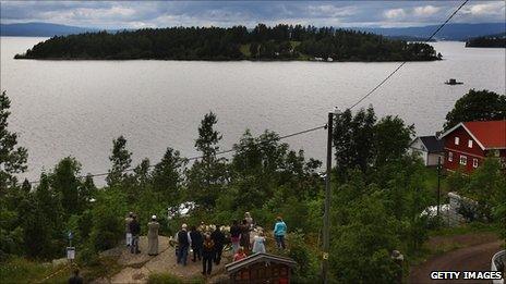 People lay flowers at Tyrifjorden Lake next to Utoeya island on 25 July 2011