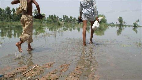 People wade through floods in Layyah district