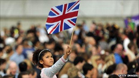 Girl in the crowd at Trafalgar Square waves a Union Flag