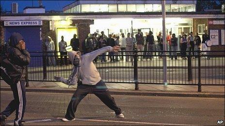 Man throws a missile during rioting in Enfield