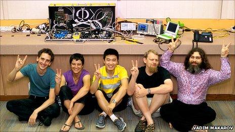 Scientists posing with Eve machine in suitcase