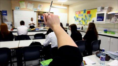 Pupil putting up hand in classroom