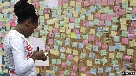 Woman writing a message for Peckham's "Wall of Love"