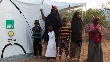 Families outside their new tent at Ifo II camp on Thursday 18 August 2011 - (Photo: BBC's Kelvin Brown)