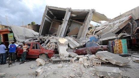 A group of men standing in rubble after an earthquake in Haiti.