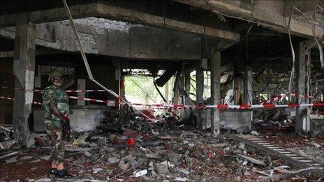 A soldier stands guard next to the damaged UN headquarters in Abuja (27 August 2011)