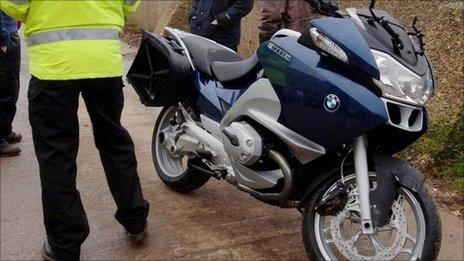 Policeman standing next to a motorbike