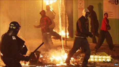 Rioters and policeman during London riots