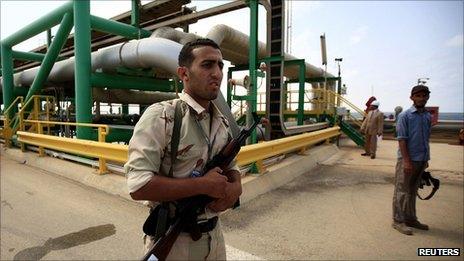 An anti-Gaddafi fighter stands guard at the Mellitah Oil and Gas complex