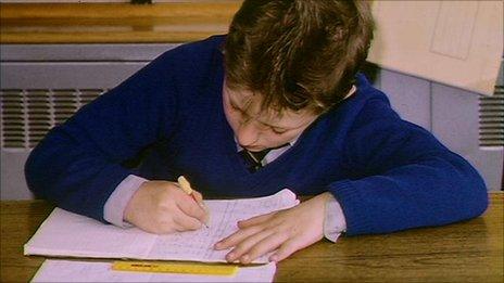 School boy writing in classroom