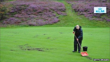 A greenkeeper repairs a green at Hilversum