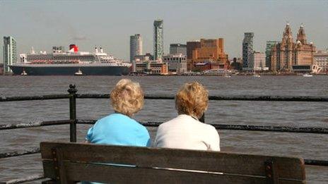 Onlookers watch the Queen Mary 2 ocean liner arrive in Liverpool