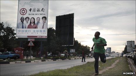 A man runs past a Bank of China billboard in Lusaka, the capital of Zambia