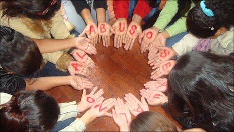 Women in Colombia form a circle with their hands to form the message "No to sexual abuse"