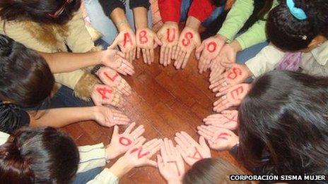 Women in Colombia form a circle with their hands to form the message "No to sexual abuse" during a self-help session in Bogota in March 2011 - photo Corporacion Sisma Mujer