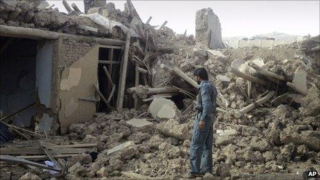 An Afghan police officer investigates the destruction from the truck bomb in Wardak on 10 September 2011