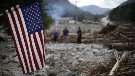 American flag hangs in front of destroyed grounds