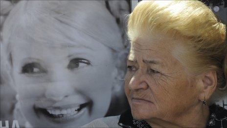 A supporter of Yulia Tymoshenko stands beside her portrait in Kiev, 5 September 2011