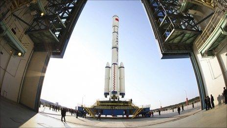 People look at the Long March II-F rocket carrying China's first space station module Tiangong-1 into orbit at the Jiuquan Satellite Launch Center in north-west China's Gansu province on 20 September 2011