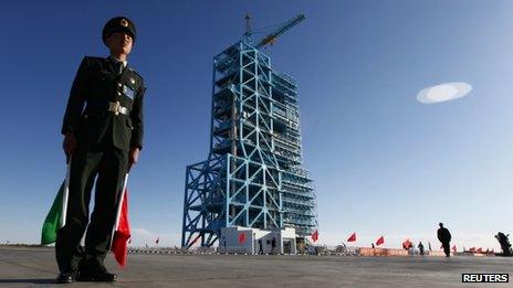 Chinese soldier stands beside Long March II-F rocket loaded with China's unmanned space module Tiangong-1 at the launch pad in the Jiuquan Satellite Launch Center, Gansu province on Wednesday