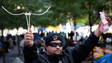 Protester Michael Pellagatti holds up the plastic handcuffs used to restrain him and the court summons he was issued