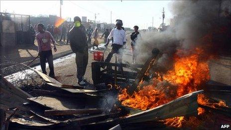 Residents watch as a shack burns down in Reiger Park, 2008