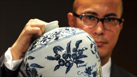 The head of Sotheby's Chinese Ceramics Department, Nicholas Chow, displaying a Ming Dynasty blue and white vase with fruit sprays