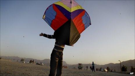 An Afghan boy, named Shams, throws up a kite on the Nader Khan hilltop in Kabul, Afghanistan, Friday 30 September 2011