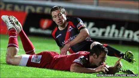 Scarlets centre Adam Warren dives over for his first try