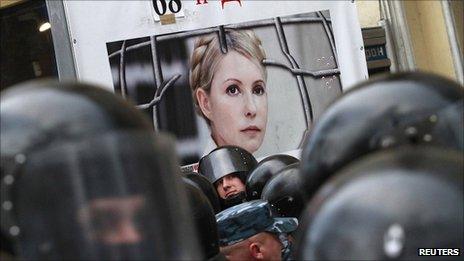 Riot police stand guard near a board displaying a portrait of former Ukraine PM Yulia Tymoshenko at a rally in Kiev