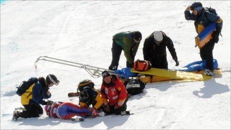 Alcott is treated on the piste after breaking her leg in Canada