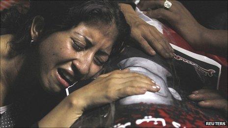 An Egyptian Christian woman mourns on the coffin of Coptic Christian Mina Daniel