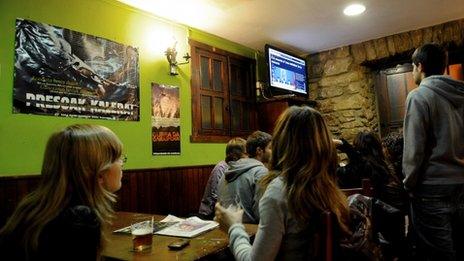 Young people watch Eta's video statement in a bar in the northern Spanish Basque city of San Sebastian, 20 October