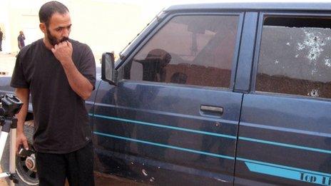 A man looks at shots in a window of a car which was used to try to stop kidnappers in Tindouf, Algeria on 23 October 2011.