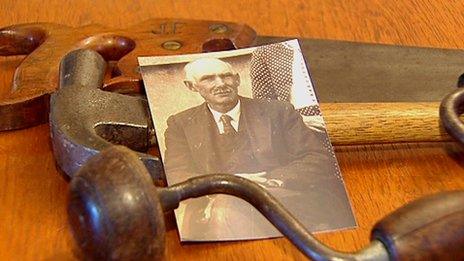 A photograph of John Flynn beside the tools of his trade