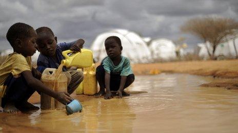 Somali boys fetching water from a puddle in Dadaab refugee camp in Kenya