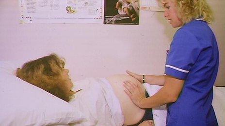 Pregnant woman having a check up by a midwife