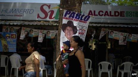 Women pass by the headquarters of a mayoral candidate for the upcoming elections in Puerto Gaitan, Meta department