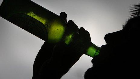 Posed image of boy drinking lager