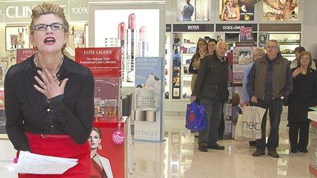 Welsh National Opera performer Anne Williams-King shows her anguish at the cosmetics counter in Debenhams as shoppers watch