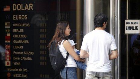 A couple wait outside a closed foreign exchange house in the Argentine capital, Buenos Aires