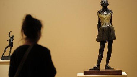 A woman looks at Degas' La Petite Danseuse de Quatorze Ans