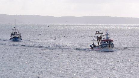 Guernsey fishing boats returning to St Peter Port Harbour with Sark in the background