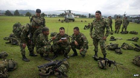 Colombian soldiers who took part in the raid against Alfonso Cano listen to news at a military base in Popayan