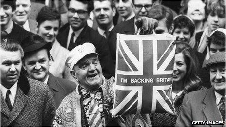 19th March 1968: A man holds up a plastic carrier bag declaring I'm Backing Britain