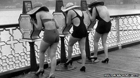 Holidaymakers back in 1935 look at picture peep shows on the pier at Llandudno