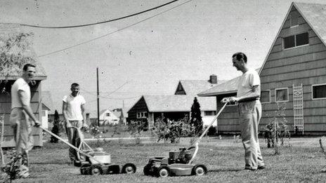 Men mow lawns in 1950s Levittown